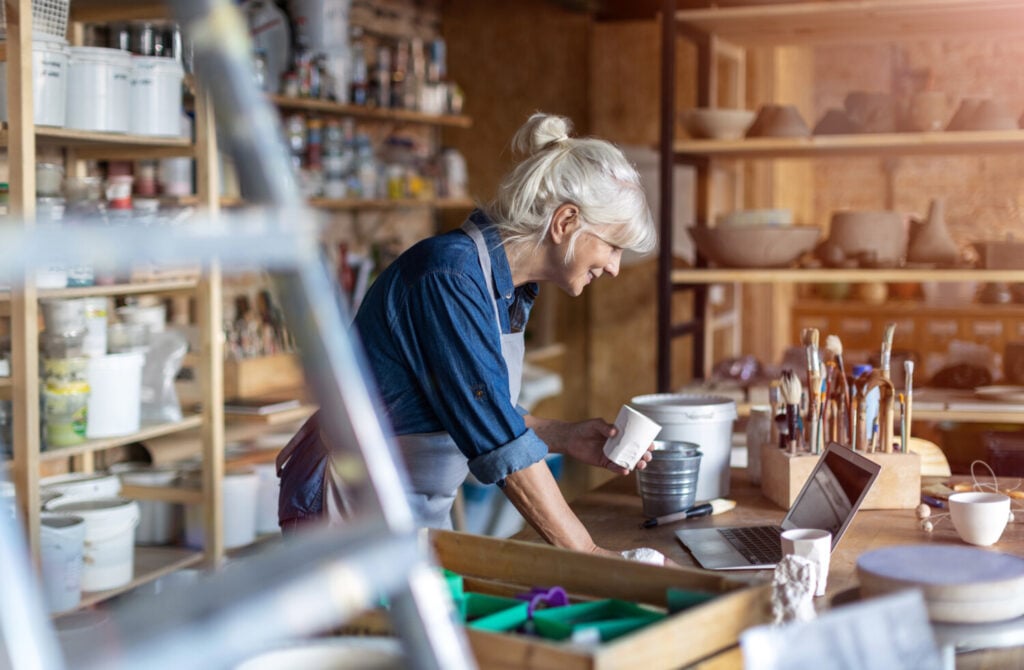 Older woman working at an art studio shop in her commercial small business